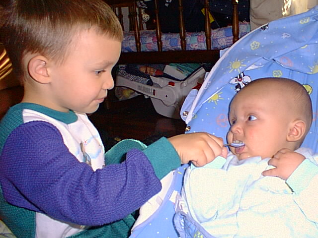 Timothy is feeding Elijah his first bowl of cereal.