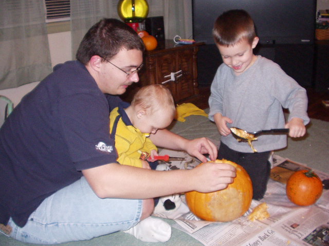 Timothy is scooping out the seeds while Elijah thinks about carving the pumpkin :)