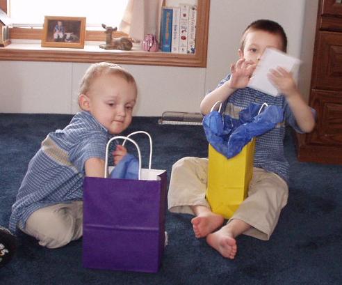 Elijah is trying to see if there is anything else in the bag & Timothy is looking at his card.