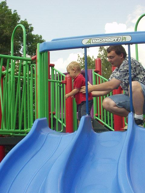 Daddy was trying to talk Elijah into going down the slide.