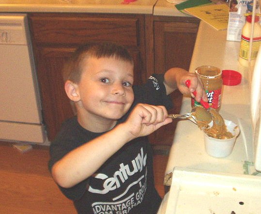 Timothy is scooping out peanut butter for one of his 4-H projects.