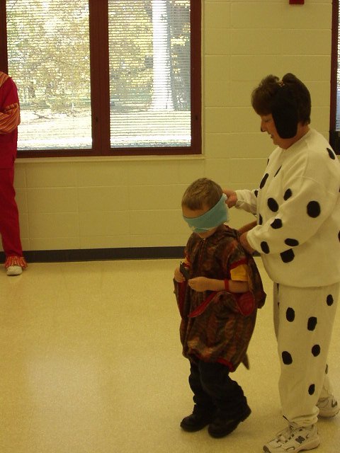Elijah is headed over to the pumpkin to put it's nose on.