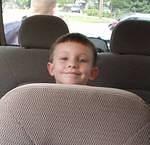 Timothy is sitting in the back seat ready to go home from school :):)